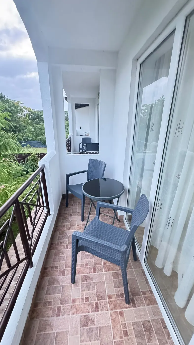 Balcon privat cu masă rotundă și două scaune
