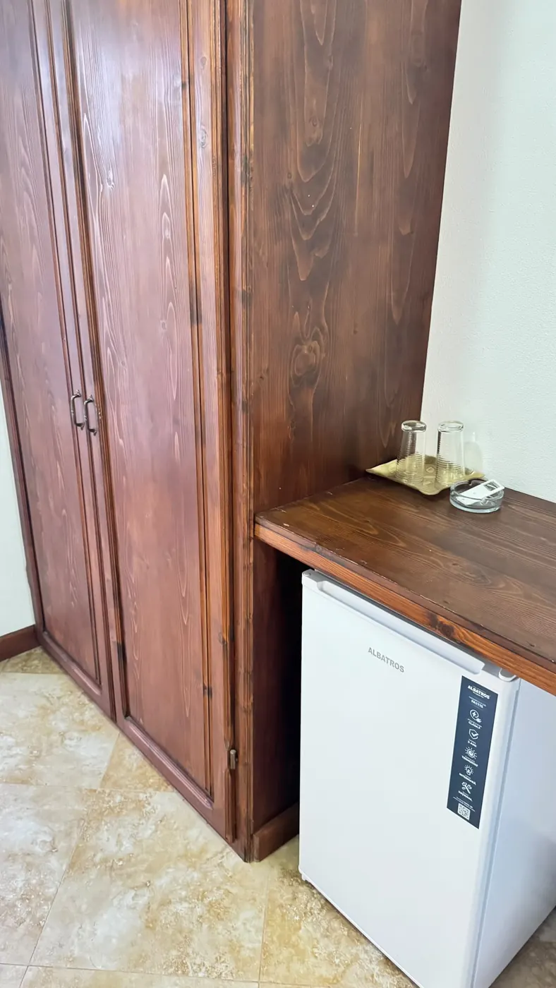Minibar și pahare pe blatul de lemn din cameră